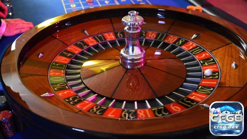 So sánh Baccarat vs Roulette: Trò nào phù hợp với bạn hơn? Bánh xe Roulette đang quay cùng các ô số đỏ đen và quả bóng nhỏ chuẩn bị dừng lại.