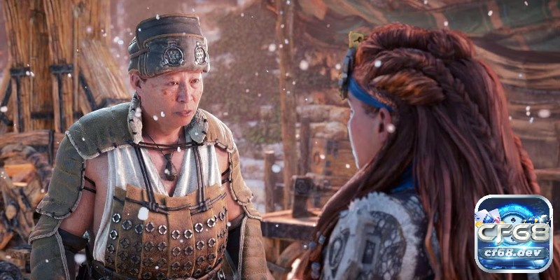 Game Horizon Forbidden West: Cuộc đi săn quái máy khổng lồ Cận cảnh Aloy trò chuyện với một NPC trong làng, biểu cảm rõ ràng và bối cảnh đông người phía sau