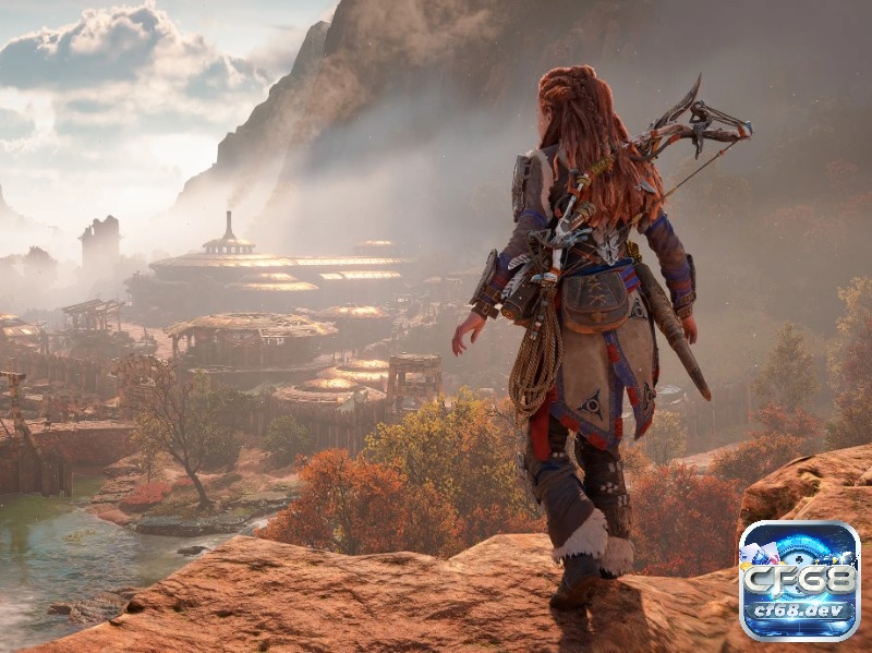 Game Horizon Forbidden West: Cuộc đi săn quái máy khổng lồ Aloy đứng trên mỏm đá nhìn xuống tàn tích ngập cát ở Miền Tây Cấm, phía xa là bầy máy canh gác trong game Horizon Forbidden West